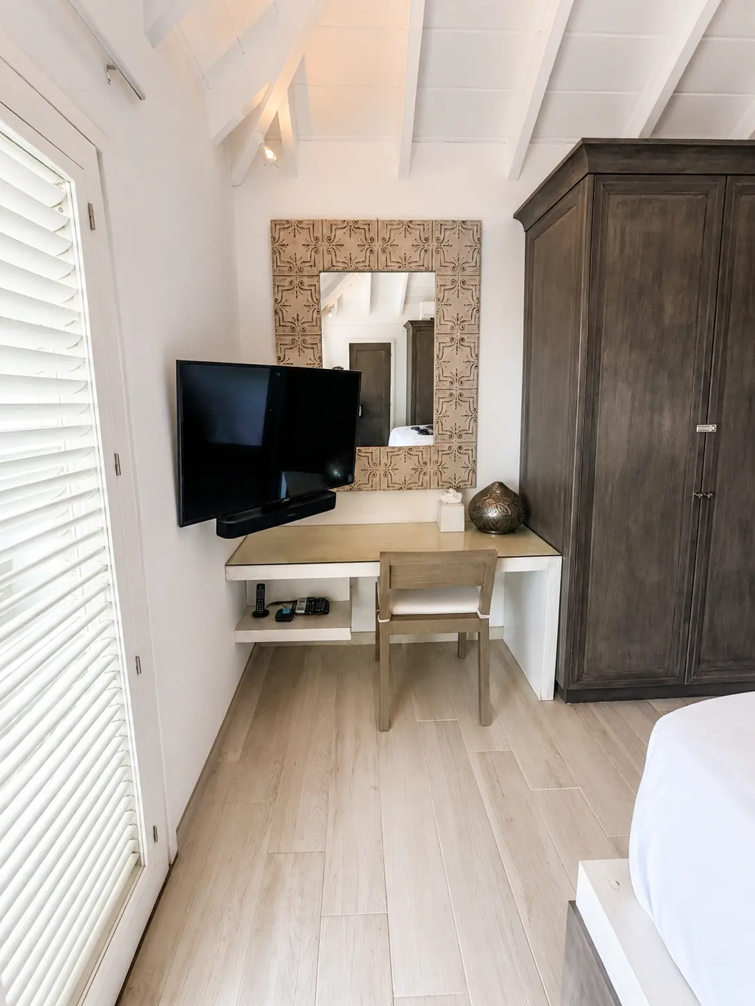 Bedroom desk area with mirror and louvered shutters