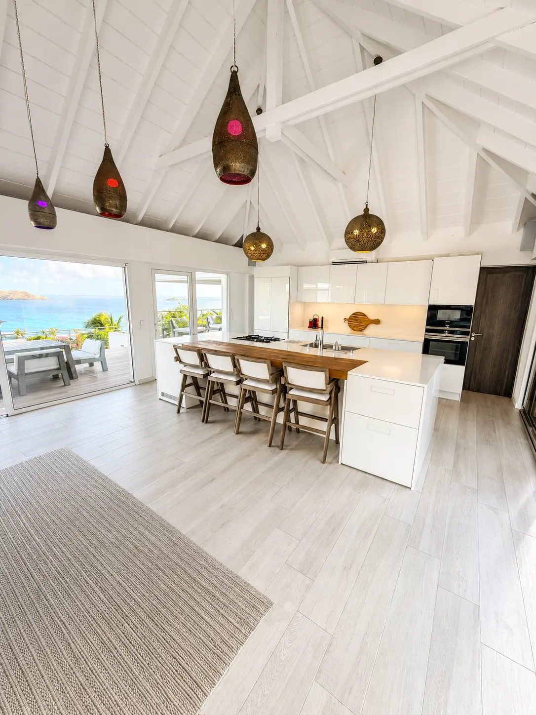 Kitchen with island seating and open doors to the sea view terrace