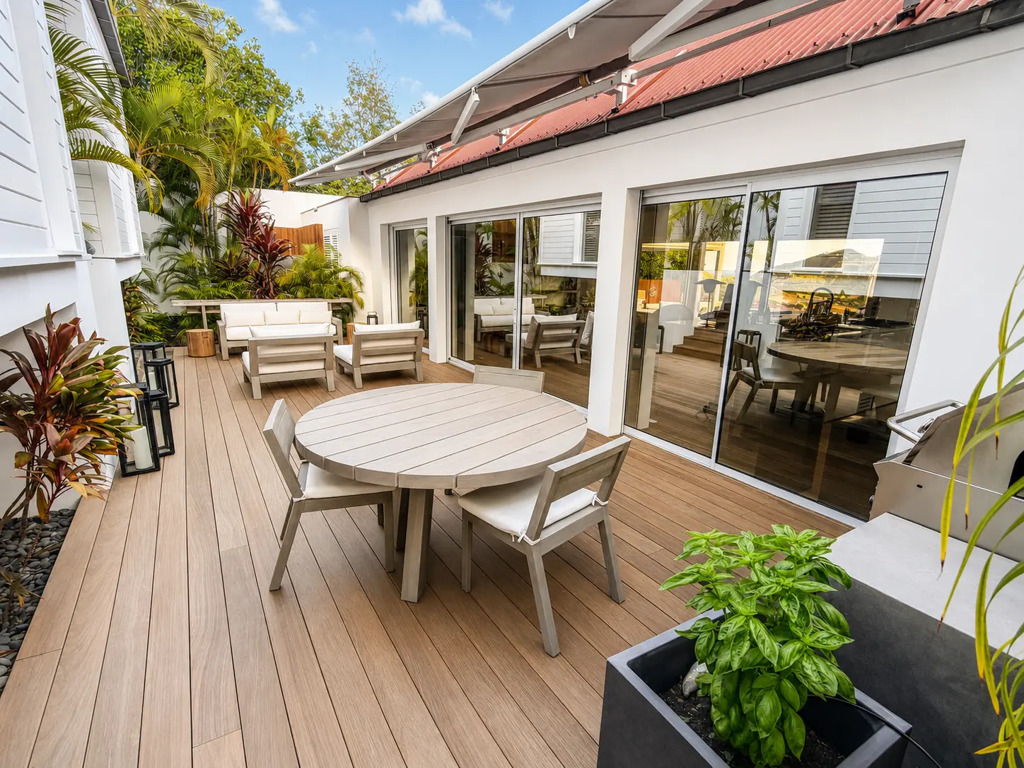 Rear patio with a round dining table, lounge seating and barbecue