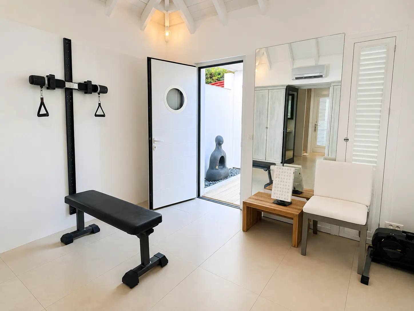 Fitness room with wall-mounted trainer and door to the courtyard