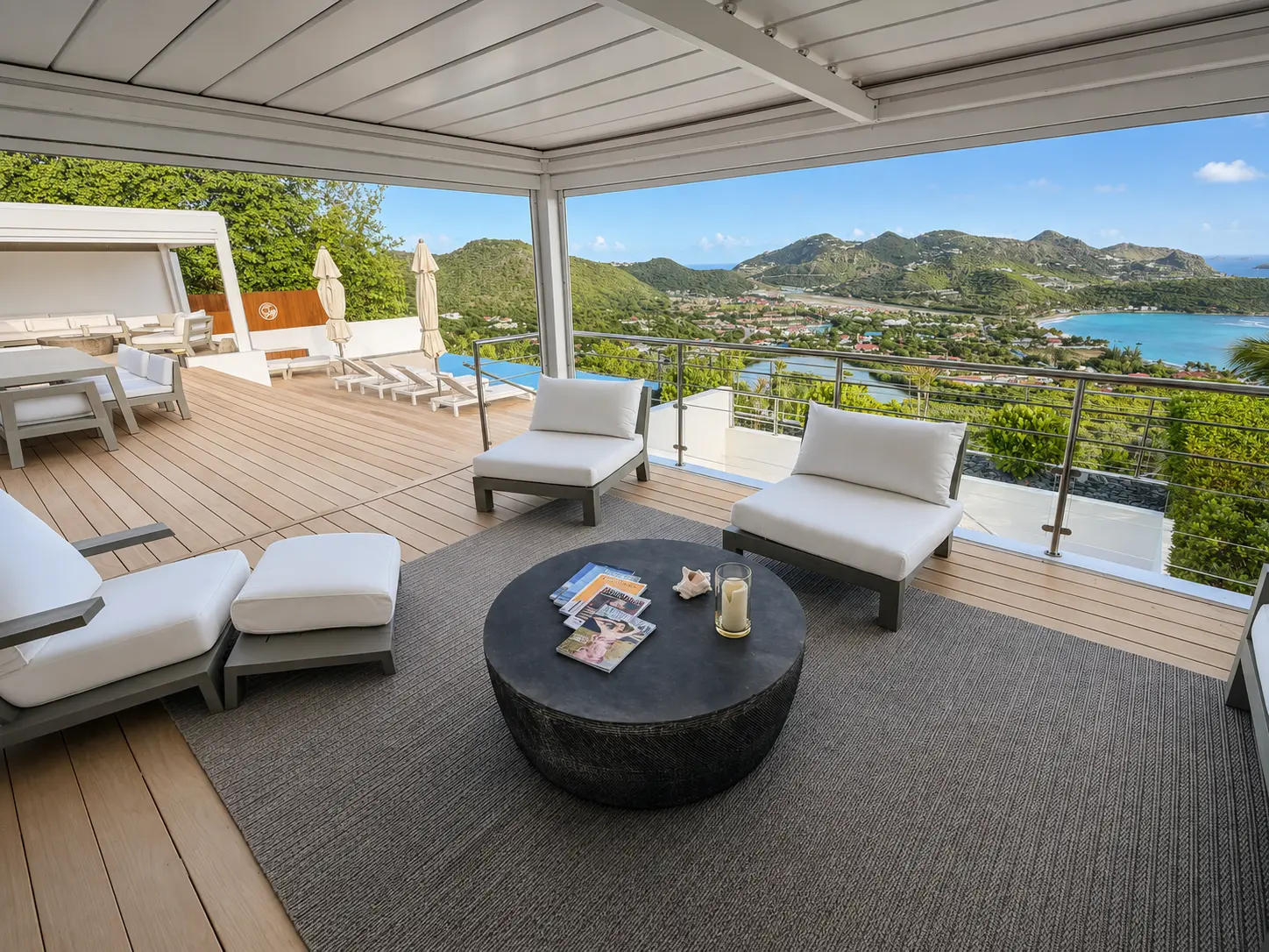 Shaded pergola lounge on the pool terrace looking across the hills to the bay