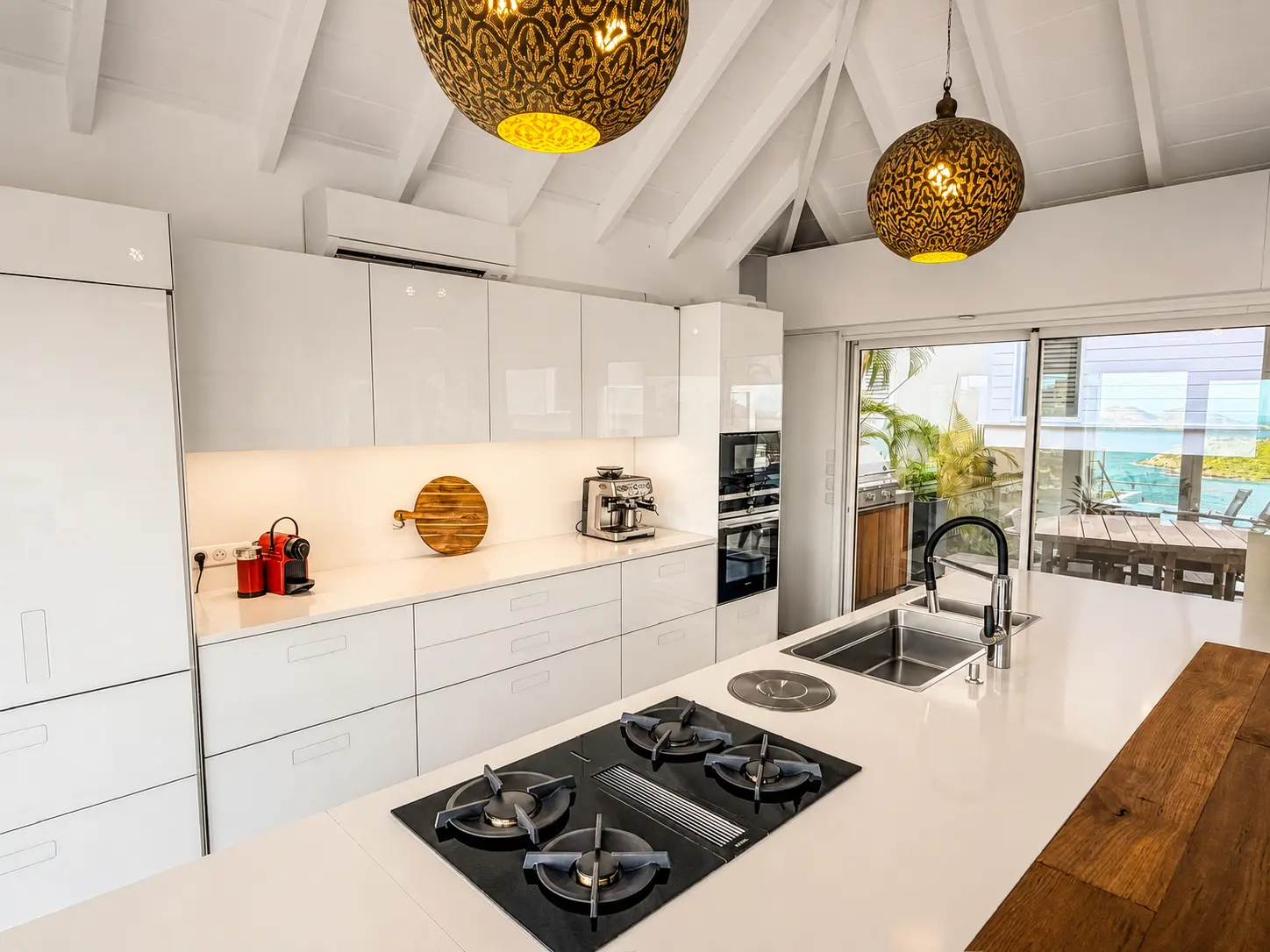 Kitchen island with gas cooktop and brass pendant lighting