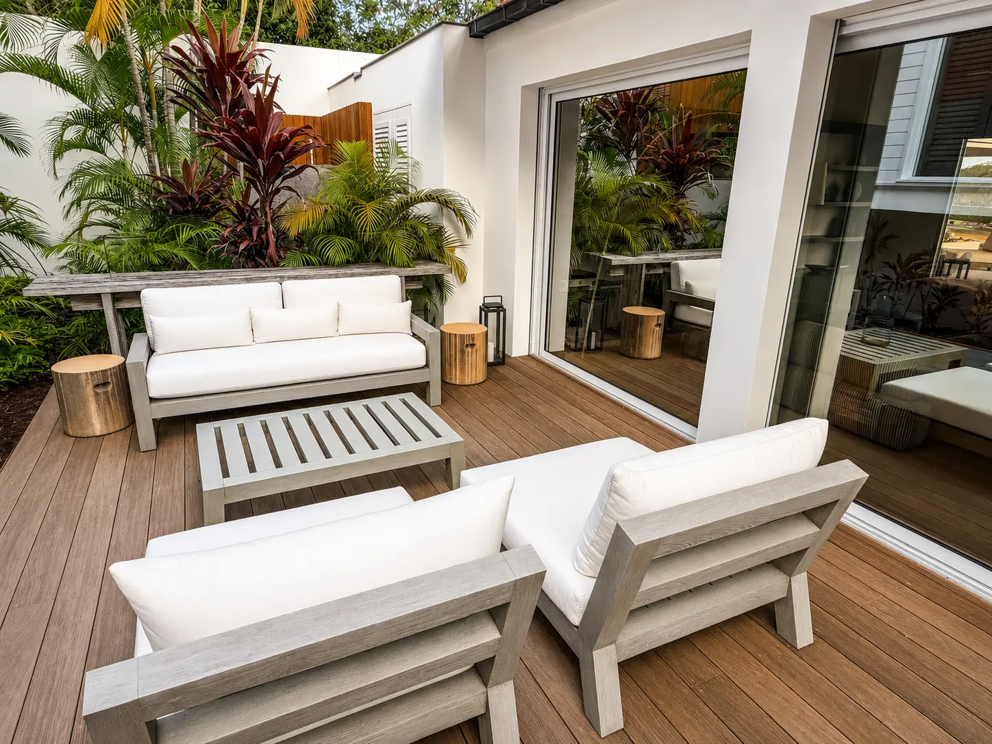 Outdoor sofas on the deck surrounded by tropical planting