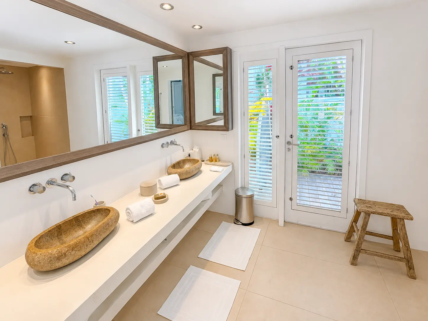 Bright bathroom with stone basins and shuttered garden doors