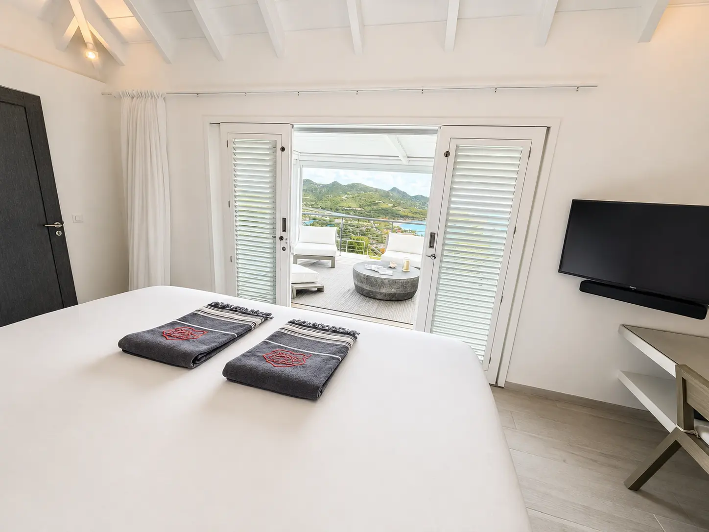Bedroom suite looking out through open doors to its ocean-facing pergola