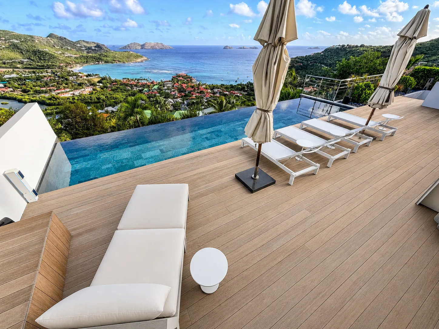 Infinity pool and sun loungers on the teak deck above St. Jean Bay and the offshore islets